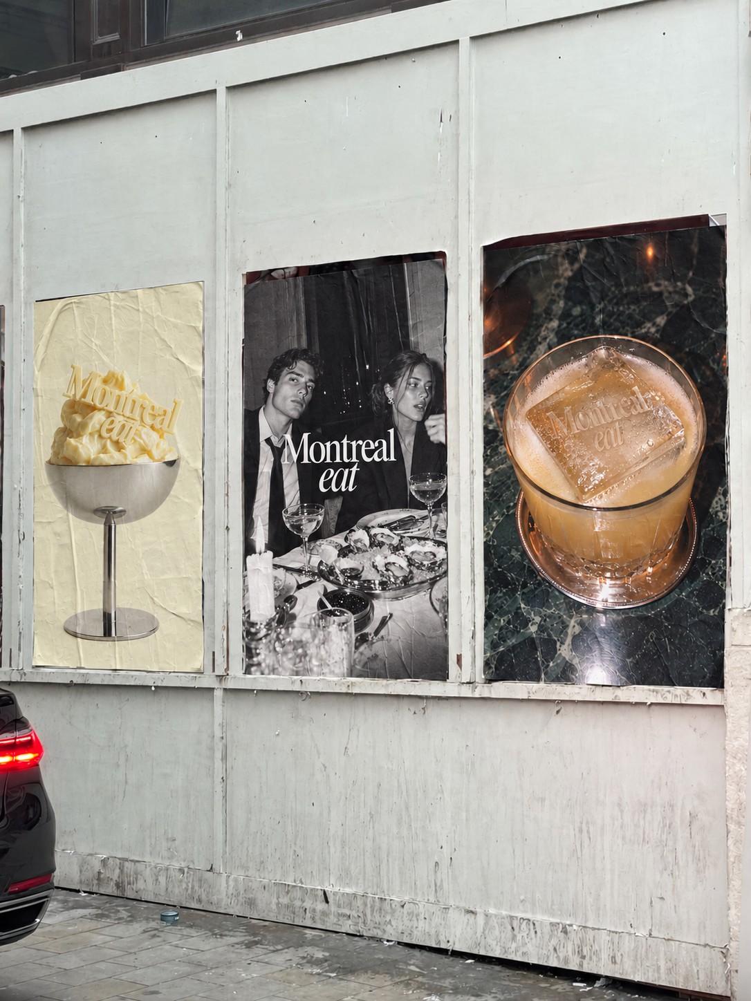 Three Montreal Eat campaign posters pasted on a street wall